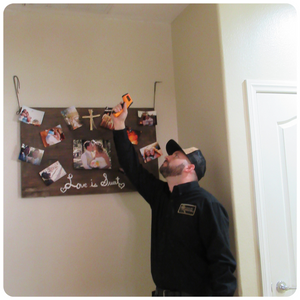 Man in black inspecting the ceiling with equipment in hand, conducting a thorough inspection