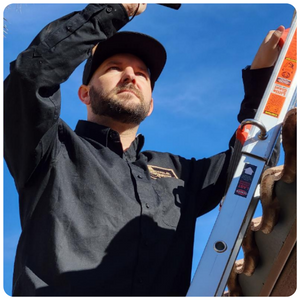 Man in black shirt conducting a roof inspection, ensuring the integrity and safety of the structure